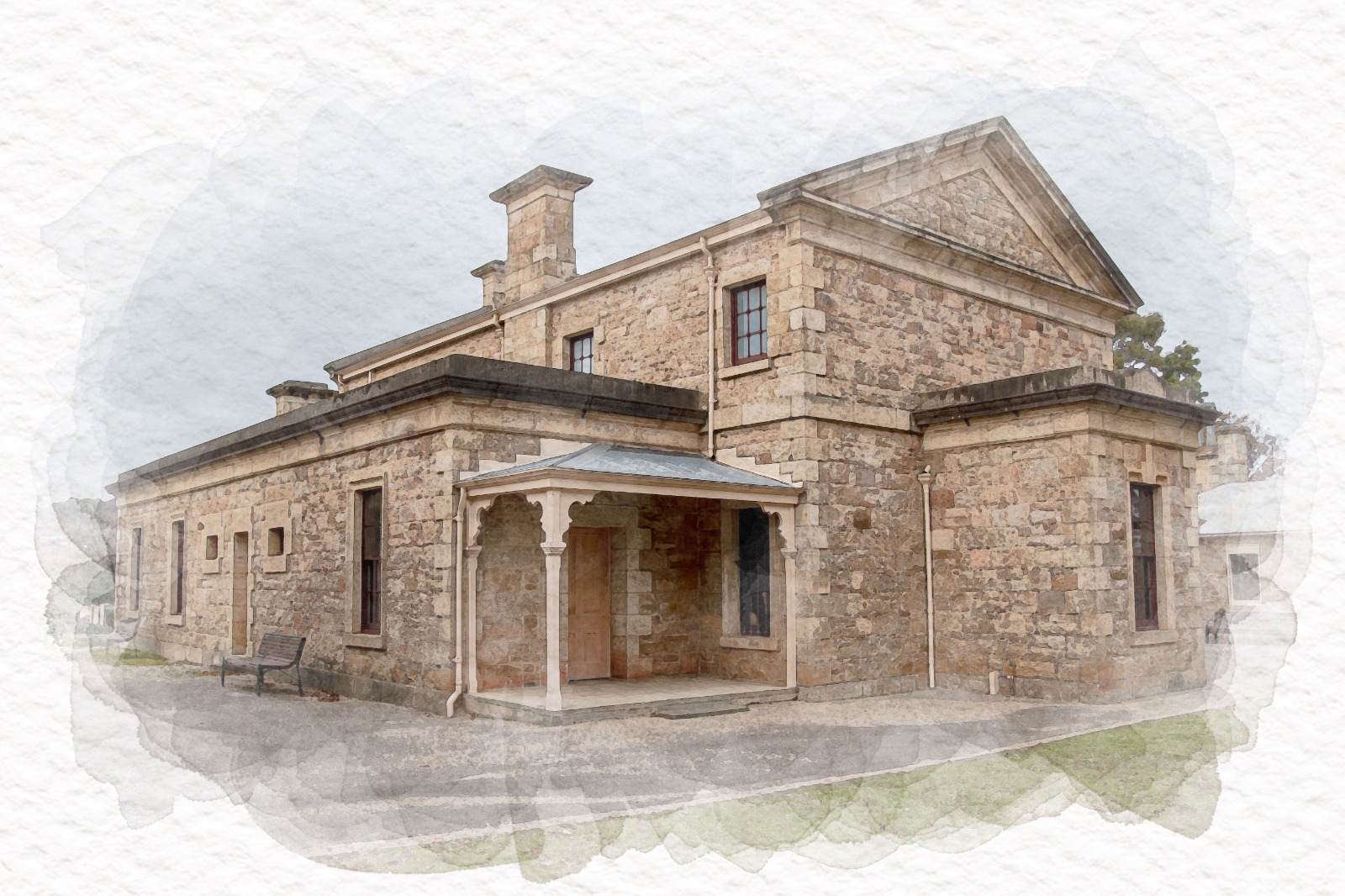 A large historic stone building with chimneys, deep windows, and a verandah-covered entrance.